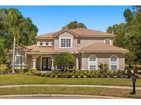 Stunning two-story home with a manicured front lawn, lush landscaping and a lovely clay tile roof at 1185 Cypress Loft Pl, Lake Mary, FL 32746