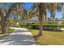 Charming one-story home with manicured landscaping, mature trees, and a long driveway leading to the entrance at 1285 Seminole Ave, Longwood, FL 32750