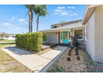 Charming home featuring a welcoming, light-blue front door and well-maintained landscaping, complemented by gravel and palm trees at 1519 N Westmoreland Dr, Orlando, FL 32804