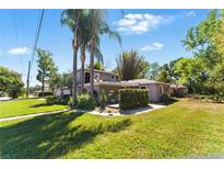 A home's landscaped front yard showcasing its lush green lawn and tropical palm trees at 1519 N Westmoreland Dr, Orlando, FL 32804