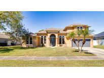 Charming home with a well-manicured lawn, two-car garage, and beautiful trees at 2238 Amberly Ave, Orlando, FL 32833