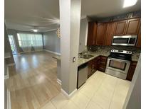 Modern kitchen featuring stainless steel appliances, tile backsplash, and wood cabinets at 2624 Robert Trent Jones Dr # 610, Orlando, FL 32835