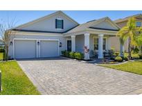 Charming single-story home with a well-maintained lawn, brick driveway, and a two-car garage at 430 Brunswick Dr, Davenport, FL 33837