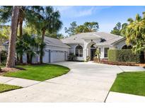 Beautiful single-story home with arched entrance, three-car garage, lovely landscaping and circular driveway at 4622 Warrington Dr, Orlando, FL 32826