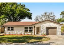 Charming single-story home showcasing stone accents, manicured lawn, and a cozy, inviting entrance at 6301 Sunshine St, Orlando, FL 32818