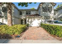 Charming two-story townhome with a one-car garage, manicured bushes, and a brick driveway at 6847 Sperone St, Orlando, FL 32819