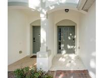 Inviting entryway with two arched doors and sunlit walkway to home at 6847 Sperone St, Orlando, FL 32819
