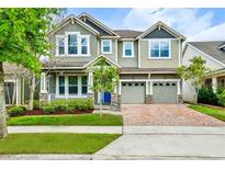 Charming two-story home featuring a brick driveway, manicured lawn, and a welcoming porch at 8433 Corkfield Ave, Orlando, FL 32832