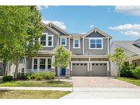 Charming two-story home featuring a brick driveway, two-car garage, and beautifully landscaped front yard at 8433 Corkfield Ave, Orlando, FL 32832