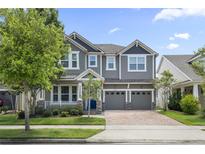 Beautiful two-story home with manicured lawn, brick driveway, and a welcoming covered front porch at 8433 Corkfield Ave, Orlando, FL 32832