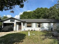 Charming one-story home with a covered carport and a front yard under a blue sky at 1339 Croyle Dr, Orlando, FL 32811