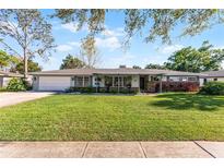 Charming single-story home features a manicured lawn and a classic, inviting facade at 2178 Whitehall Dr, Winter Park, FL 32792