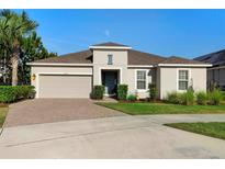 Charming one-story home with a brick driveway, well-maintained landscaping, and a two-car garage at 3375 Hanging Tide St, Winter Garden, FL 34787