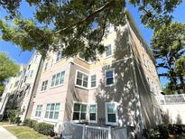 Low angle view of a modern multi-story condo building with a stucco exterior and white window trim at 3384 Corona Village Way # 202, Orlando, FL 32835