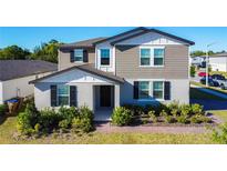 Charming two-story home featuring a landscaped yard, neutral color palette and inviting covered entryway at 5251 Meredrew Ln, St Cloud, FL 34771