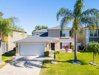 Charming two-story home features a well-manicured lawn, lovely landscaping, and an attached two-car garage at 543 Flower Fields Ln, Orlando, FL 32824