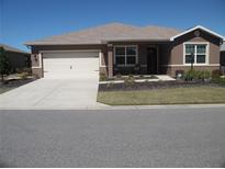 Charming single-story home with a well-manicured lawn, a two-car garage, and a welcoming front porch at 8824 Sw 104Th Cir, Ocala, FL 34481