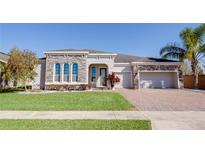 Beautiful single-story home with stone accents, brick driveway, and well-manicured lawn at 1009 Birch Hollow Dr, Apopka, FL 32703