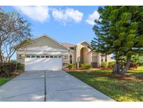 Charming single-story home featuring manicured landscaping, a two-car garage and a concrete driveway at 1521 Gants Cir, Kissimmee, FL 34744