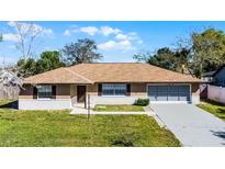 Charming single-story home featuring a brick facade, well-manicured lawn, and attached two-car garage at 2072 Monterey Dr, Deltona, FL 32738