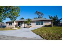 Charming home with a well-maintained lawn, inviting driveway, and beautiful landscaping at 345 W Seminole Ave, Eustis, FL 32726