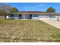 Charming one-story home with blue exterior, white trim, brown roof, and attached garage at 6 Almond Trce, Ocala, FL 34472