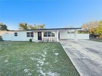 Charming single-story home featuring a well-manicured lawn and a covered carport at 6003 W Harwood Ave, Orlando, FL 32835
