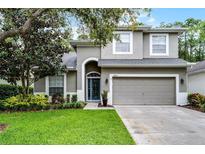 Charming two-story home with well-manicured lawn and attached two-car garage at 9899 Leland Dr, Orlando, FL 32827