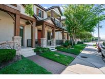 Charming townhouse with stone accents, well-manicured lawn, and inviting covered entryway at 10655 Village Lake Rd, Windermere, FL 34786