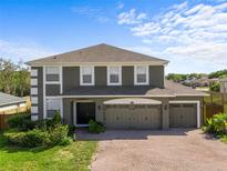 Charming two-story home boasts a three-car garage, manicured lawn, and mature landscaping at 110 Wekiva Pointe Cir, Apopka, FL 32712