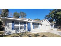 Charming single-story home with blue door, blue shutters, and a well-manicured lawn at 111 Sunnyside Dr, Clermont, FL 34711