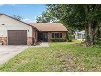Charming single-story home with brick accents, manicured lawn, and mature trees on a sunny day at 1148 Monroe Ave, St Cloud, FL 34769