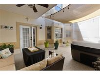 Cozy covered patio with hot tub, ceiling fan, comfortable seating, and decorative lighting at 13326 Fountainbleau Dr, Clermont, FL 34711