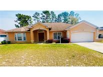 Charming single-story home featuring a well-maintained lawn and an attached two-car garage at 13405 Sw 86Th Ave, Ocala, FL 34473