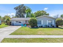 Charming home featuring a well-maintained lawn, mature landscaping and updated gray exterior paint at 3420 Arnel Dr, Winter Park, FL 32792