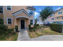 Inviting townhome entrance with a black door, trimmed in white, and a landscaped front yard at 3433 Soho St # 101, Orlando, FL 32835