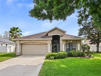 Charming single-story home featuring a manicured lawn, well-maintained landscaping, and a two-car garage at 405 Carriage Way Ct, Oviedo, FL 32765