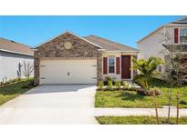 Charming single-Gathering home showcasing a stone facade, two-car garage and a well-manicured lawn at 4176 Sagefield Dr, Harmony, FL 34773