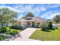 Charming single-story home with well-manicured lawn, lush landscaping, and a long driveway at 4536 Barrister Dr, Clermont, FL 34711
