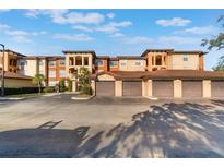 Exterior of a modern condo building featuring private garages, stucco finish, and red tile roof at 5578 Metrowest Blvd # 310, Orlando, FL 32811