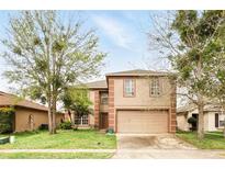 Charming two-story home with a two-car garage, well-maintained lawn, and mature trees offering shade at 750 Sterling Spring Rd, Orlando, FL 32828