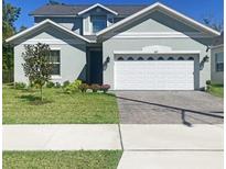 Charming two-story home with a well-manicured lawn and a two-car garage with a beautifully paved driveway at 827 Dennis Ave, Orlando, FL 32807
