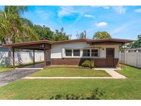 Charming single-story home with a carport and well-maintained front lawn in a residential area at 1103 Timor Ave, Orlando, FL 32804