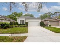 Well-maintained home featuring a two-car garage, manicured lawn, and trimmed hedges for curb appeal at 113 Golden Crest Ct, Winter Springs, FL 32708
