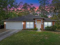 Charming single-story home featuring a two-car garage, warm stucco exterior, and well-manicured front lawn at 1234 1St Ave, Deland, FL 32724
