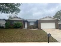 Inviting single-story home featuring a well-maintained lawn and an attached two-car garage at 1415 Meadowlark St, Longwood, FL 32750