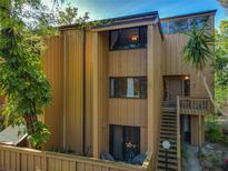 Exterior view of a two-story townhome with a private balcony, neutral paint and surrounding trees at 225 Crown Oaks Way, Longwood, FL 32779