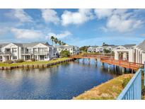 Waterfront community featuring canal, bridge, and beautiful landscaping under sunny skies with scattered clouds at 2568 Woodgate Blvd # 204, Orlando, FL 32822