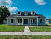 Charming two-story home with blue trim, three dormer windows, and a well-manicured lawn at 311 W Delaware Ave, Lake Helen, FL 32744