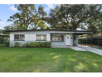 Charming single-story home featuring a well-maintained lawn and a covered carport with decorative iron supports at 3214 Debbie Dr, Orlando, FL 32806